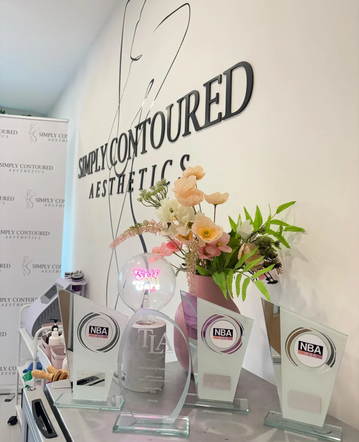 Simply Contoured Aesthetics' TLA and NBA award trophies in the Cardiff Bay clinic